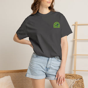 Person wearing a dark gray t-shirt with a bluegrass flow logo, standing against a neutral background.