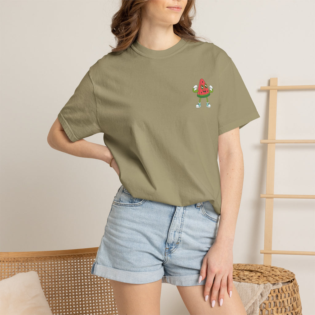Person wearing a green t-shirt with Mel the Melon flexing and denim shorts against a neutral background