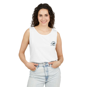 Woman wearing a white sleeveless top with bluegrass flow logo and light blue jeans on a white background