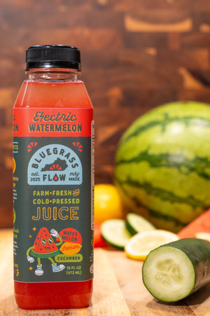Bottle of Bluegrass Flow juice with watermelon and cucumber on a wooden surface