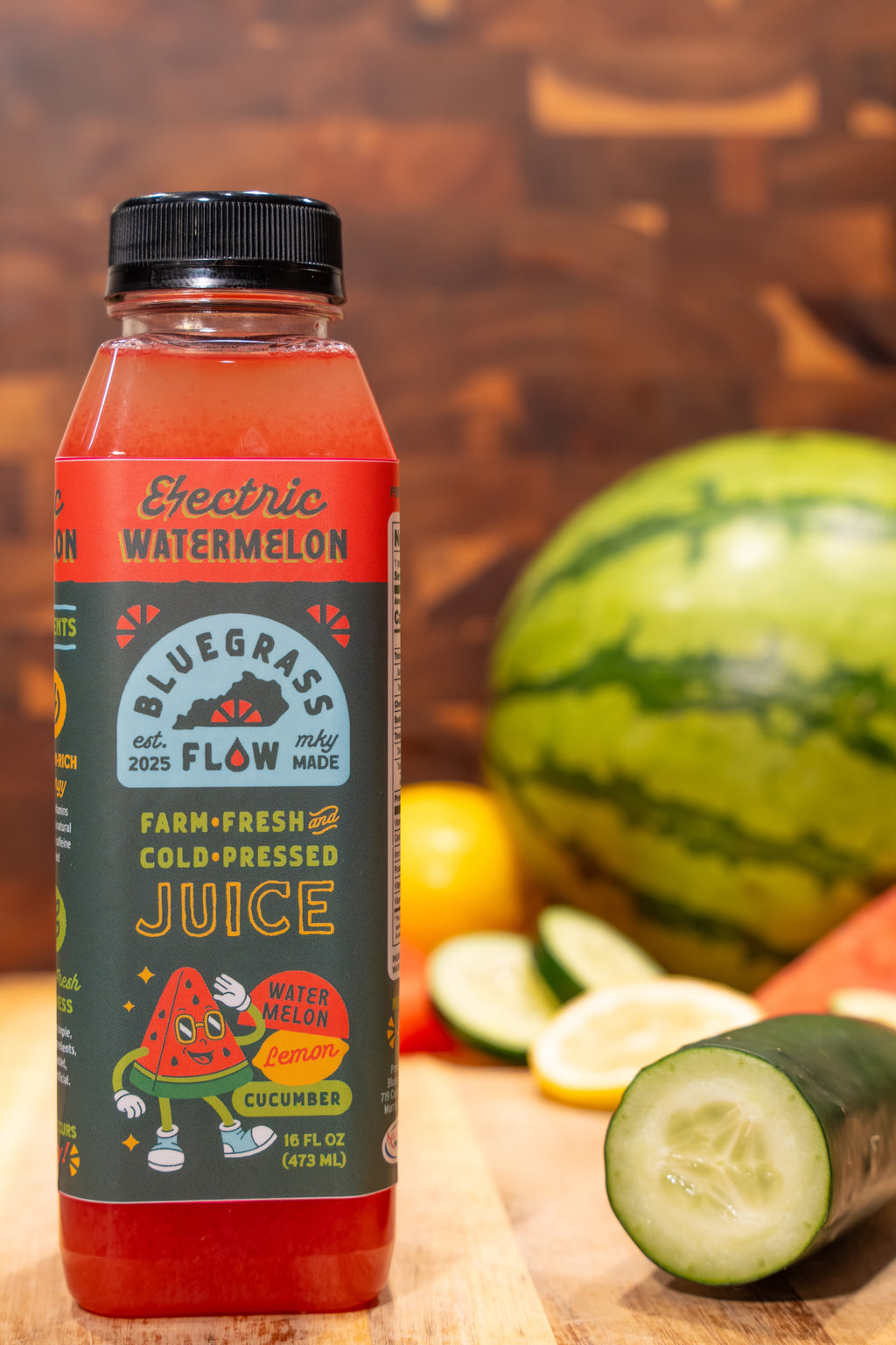 Bottle of Bluegrass Flow juice with watermelon and cucumber on a wooden surface